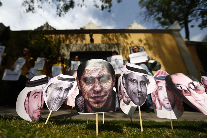 A picture of Saudi blogger Raif Badawi (C) is seen between others photos of prisoners in Saudi Arabia during a demonstration for his release from jail outside the Embassy of Saudi Arabia in Mexico City, February 20, 2015. (Reuters/Edgard Garrido)