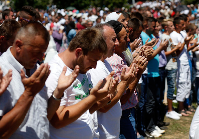 People pray during a reburial ceremony of 136 newly identified victims in Potocari, near Srebrenica, Bosnia and Herzegovina July 11, 2015 (Reuters)