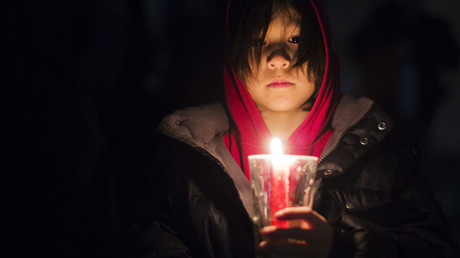 Petite fille tenant une bougie lors d'une manifestation pour les droits des peuples autochtones
