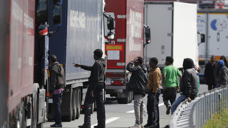 Des migrants tentent de monter dans des camions, aux abords de l'Eurotunnel
