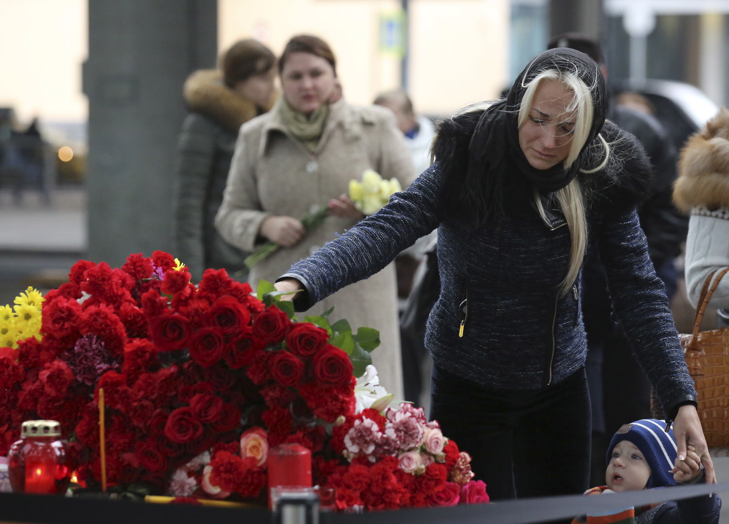Une femme dépose une gerbe de fleurs près de l'aéroport de Poulkovo à Saint-Pétersbourg, en mémoire des victimes du crash