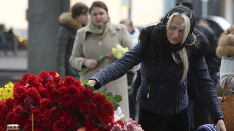 Une femme dépose une gerbe de fleurs près de l'aéroport de Poulkovo à Saint-Pétersbourg, en mémoire des victimes du crash