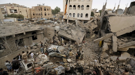 A Sanaa, capitale du Yémen, des gens se rassemblent autour des décombres de maisons détruites.