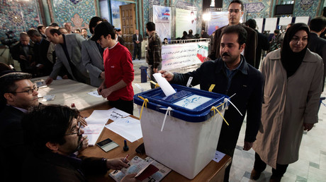 Un homme dépose son bulletin de vote dans l’urne lors des élections législatives iraniennes le 2 mars 2012