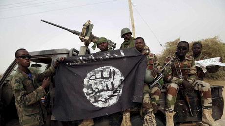 Les soldats nigériens tiennent un drapeau de Boko Haram qu'ils avaient saisi dans la ville de Damasak, au Nigeria