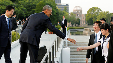 Le président des Etats-Unis Barack Obama, accompagné du Premier ministre japonnais Shinzo Abe (gauche) , salue une écolière au Mémorial de la Paix d'Hiroshima, le 27 mai 2016.