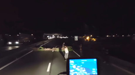 Calais : la vidéo d'un chauffeur poids lourd forçant un barrage routier édifié par des migrants