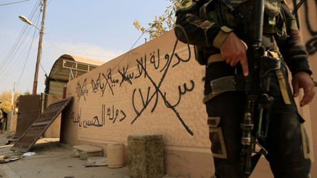 Un soldat des forces spéciales irakiennes devant un mur à Mossoul sur lequel est écrit : «L’Etat islamique restera», le 27 octobre.