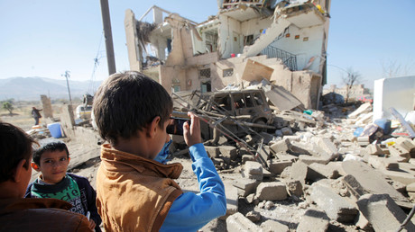 Un enfant prend en photo une maison de Sanaa détruite par un raid aérien de la coalition arabe au Yémen