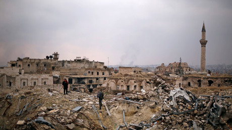 Un soldat de l'armée syrienne avec des civils dans les ruines de l'ancien hôtel Carlton d'Alep.