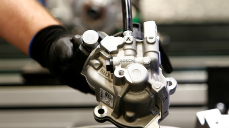 Un employé de Bosch installe un injecteur dans un moteur diesel 