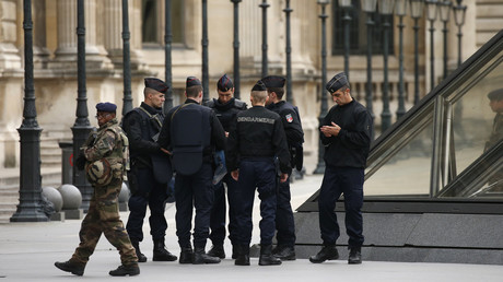 Un militaire et les gendarmes devant le pyramide du Louvre