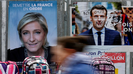 Une affiche de Marine Le Pen et une affiche dégradée d'Emmanuel Macron dans les rues de Béthune