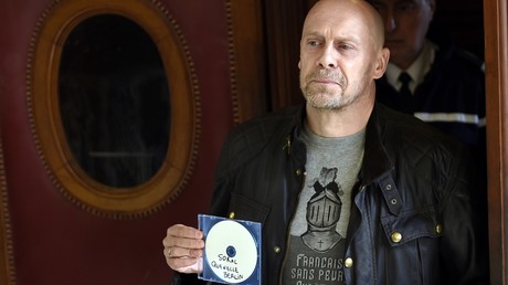 Alain Soral brandissant un CD devant la chambre où se tenait un de ses procès en 2015 à Paris