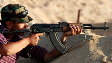 Un combattant rebelle libyen s'entraîne à tirer à la kalachnikov près de Misrata, en juin 2011