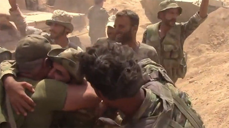 Des soldats de l'armée gouvernementale syrienne embrassent leurs compagnons d'armes après avoir libéré leur base, encerclée par l'Etat islamique depuis 2014