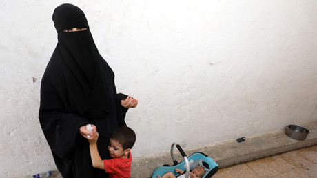 une femme dont les membres de la famille ont été accusés de faire partie de l'Etat islamique, photographiée avec ses enfants, le 22 juillet 2017 dans un camp de déplacés près du village d'Ain Issa. 