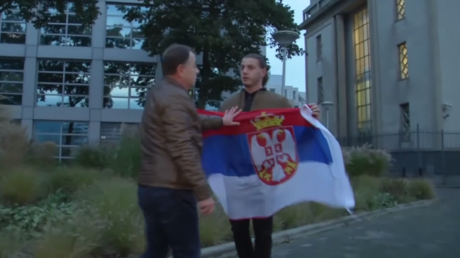 Un homme arborant un drapeau serbe se fait molester par des Bosniaques près du siège du TPIY
