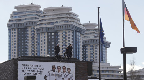 A Moscou, sur le toit de l’ambassade d’Allemagne,  des employés fixent une bannière sur laquelle est écrit, en russe : «L’Allemagne attend avec impatience le championnat du monde de football 2018» (illustration). 