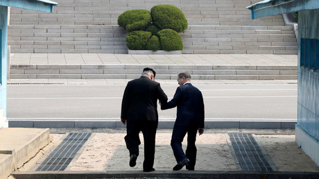 Le dirigeant nord-coréen Kim Jong Un et le président sud coréen Moon Jae In franchissent main dans la main la ligne de démarcation entre les deux Corées, le 27 avril