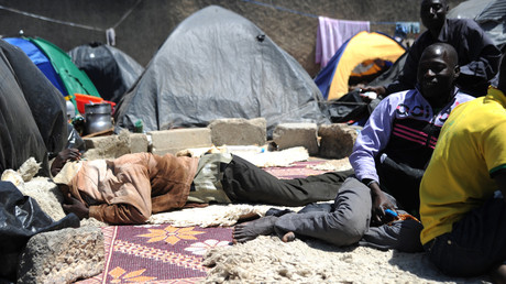 Des migrants clandestins nigériens sont assis près de leurs tentes après s'être installés près du marché aux fruits de la ville algérienne de Boufarik, à 35 km au sud de la capitale Alger