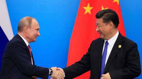 Le président chinois Xi Jinping salue Vladimir Poutine, le président russe, lors du sommet de l'Organisation de Coopération de Shanghaï (OCS) en Chine le 10 juin 2018