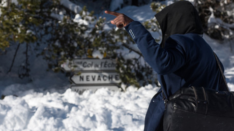 Un migrant originaire de Côte d'Ivoire pointe son doigt en direction du Col de l'Echelle depuis Bardonecchia, dans les Alpes italiennes, le 13 janvier 2018 (illustration)