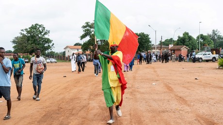 Un partisan du président sortant du Mali, Ibrahim Boubacar Keita, brandit un drapeau du Mali à Bouaké, le 22 juillet 2018