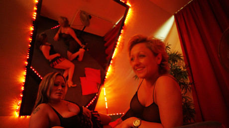 Deux prostituées posent sur un lit dans une maison close d'Hambourg en Allemagne en 2009 (image d'illustration).

