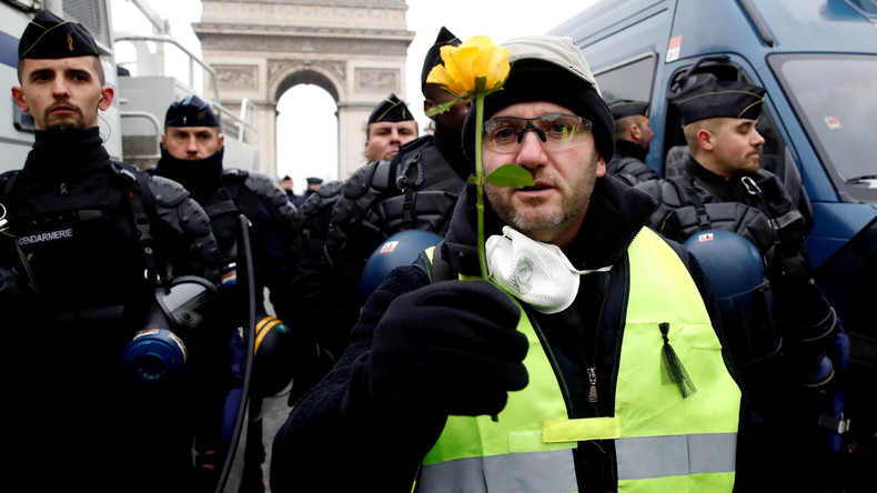 Un Gilet jaune met une fleur à l'uniforme d'un policier, son collègue l'écrase et la jette par terre