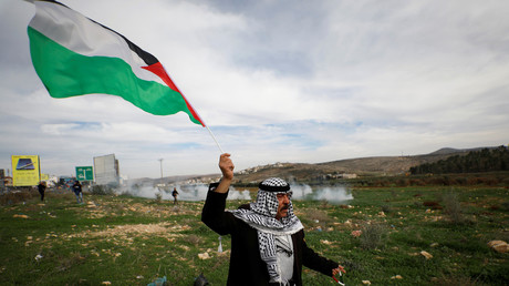 Un manifestant brandit le 2 novembre un drapeau palestinien lors d'affrontements avec des troupes israéliennes au check-point de Hawara près de Naplouse en Cisjordanie occupée