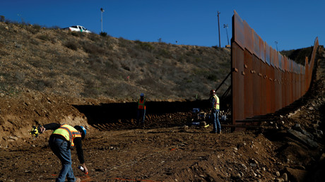 Des ouvriers tracent une ligne au sol alors qu’ils travaillent sur le mur à la frontière entre le Mexique et les Etats-Unis à Tijuana au Mexique, le 13 décembre 2018.