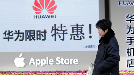 Une femme passe devant un magasin vendant des articles Huawei et Apple à Pékin, en Chine, le 12 décembre 2018.