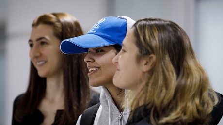 Rahaf Mohammed al-Qunun (centre), à l'aéroport de Toronto, à côté du chef de la diplomatie Chrystia Freeland (droite)