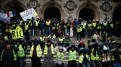 Des Gilets jaunes mains sur la tête en référence à l'arrestation de lycéens, devant l'Opéra Garnier à Paris, le 15 décembre.