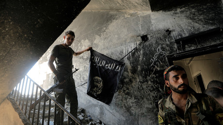 Des combattants des Forces démocratiques syriennes récupèrent un drapeau de l'Etat islamique à Raqqa, le 14 août 2017 (image d'illustration).