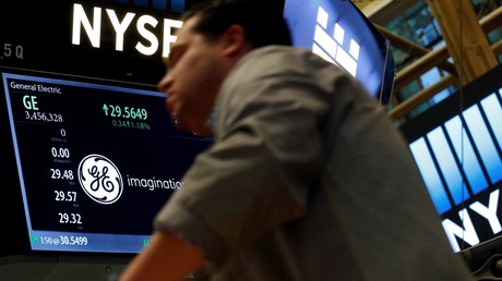Un trader passe devant un écran affichant la cotation de l’action du groupe General Electric à la Bourse de New York (NYSE), le 31 octobre 2016. Depuis cette photo, le cours de l’action a presque été divisé par quatre (illustration).