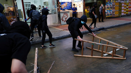 Des manifestants déplacent du mobilier urbain lors d'un rassemblement à Hong Kong, le 10 mai 2020.