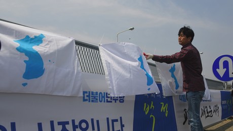 Un homme installe un drapeau en faveur de l'unification de la péninsule coréenne à Paju, Corée du Sud, en avril 2018, en amont d'un sommet inter-coréen (image d'illustration).
