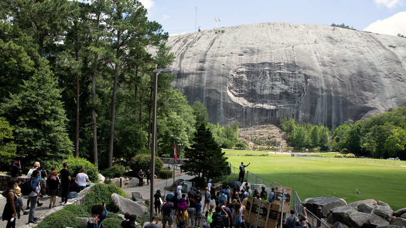 Cagoulés et armés, des militants afro-américains manifestent devant un symbole confédéré