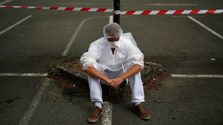 Un soignant, portant une combinaison de protection et un masque, fait une pause, près de l'hôpital de Laval, Mayenne, France