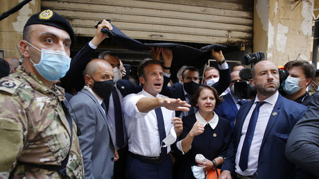 Le président de la République française Emmanuel Macron visitant une rue dévastée de Beyrouth le 6 août.