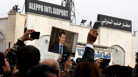 Des gens brandissent une photo du président syrien Bachar al-Assad à l'aéroport d'Alep, février 2020 (image d'illustration).