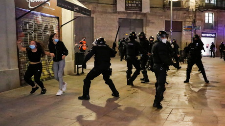 Des manifestants courent pour échapper à la police lors de la manifestation contre les restrictions de circulation à Barcelone, le 30 octobre 2020.