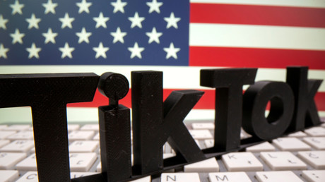 Le logo de la célèbre application TikTok placé sur un clavier, devant le drapeau des Etats-Unis (image d'illustration)
