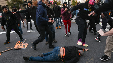 Un militant pro-Trump gisant sur le sol est frappé par des manifestants anti-Trump au Black Lives Matter Plaza à Washington DC, le 14 novembre 2020.