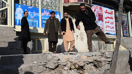 Des hommes observent les dommages causés par des tirs de roquettes à Kaboul le 21 novembre 2020