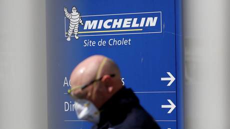 Un employé passe devant l'entrée de l'usine de pneus Michelin, à Cholet, en France, le 14 avril 2020 (image d'illustration).