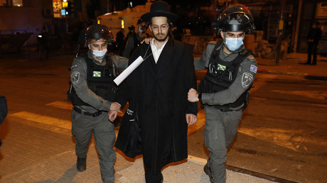 Les forces de sécurité israéliennes arrêtent un juif ultra-orthodoxe lors d'une manifestation contre les restrictions, à Jérusalem le 9 février 2021.