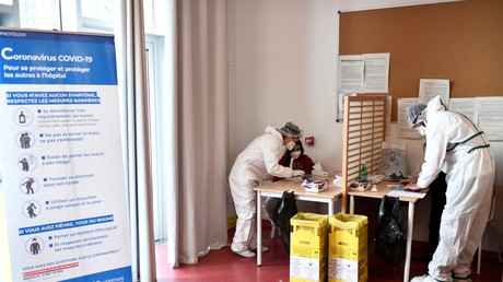 Des agents de santé collectent des échantillons auprès d'élèves dans une école à Paris, le 11 février 2021, lors d'une visite du Premier ministre et du ministre de la Santé sur la mise en œuvre des tests salivaires de Covid-19.